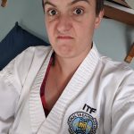 in dobok with blue belt, red stripe