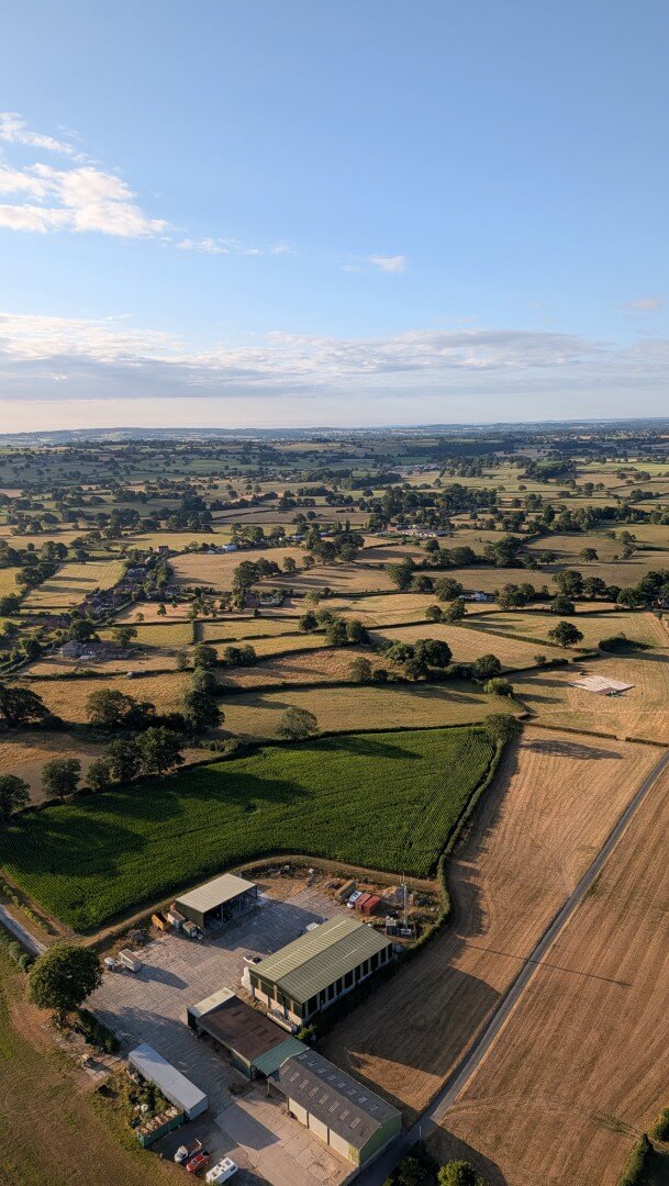A photo of a farm and surrounding fields from the air